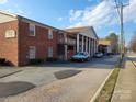 Apartment building exterior featuring parking area, classic red brick facade, and architectural column details at 2121 Carriage Woods Ln, Kannapolis, NC 28081
