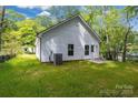 Exterior view of house with green backyard, back door, and A/C unit on the side at 408 N Boyd St, Gastonia, NC 28052