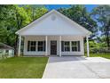 Inviting home showcasing a covered entrance, dark shutters, and a newly paved driveway at 408 N Boyd St, Gastonia, NC 28052