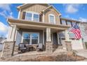 Brick porch with two wicker chairs and a table, two-story house with American flag at 5055 Stonehill Ln, Matthews, NC 28104