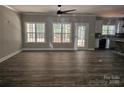 Spacious living room featuring wood floors, a modern ceiling fan, and abundant natural light from the large windows at 609 Shiloh Unity Rd, Lancaster, SC 29720