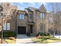 Charming brick townhome features a well-maintained lawn, attached garage and classic architectural details at 6411 Aldworth Ln, Charlotte, NC 28226