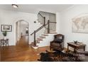 Inviting foyer with hardwood floors, staircase, archway, sitting area with leather chair and stylish decor elements at 6411 Aldworth Ln, Charlotte, NC 28226