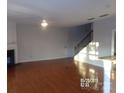 Living room with hardwood floors, fireplace and staircase at 10244 Blakeney Preserve Dr, Charlotte, NC 28277