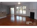 Spacious living room with hardwood floors, fireplace, and large windows at 10244 Blakeney Preserve Dr, Charlotte, NC 28277