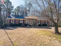 Brick ranch home with a covered porch and mature trees at 133 Devine St, Stanley, NC 28164