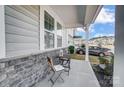 Front porch with stone detailing, seating, and a view of the neighborhood at 19117 Hawk Haven Ln, Charlotte, NC 28278