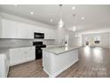 Open concept kitchen with island, white cabinets, and hardwood floors at 2242 Catawba Trace Dr, Catawba, NC 28609