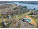 Aerial view of houses, a pool, and a lake in a community at 225 South Shore Dr, Belmont, NC 28012