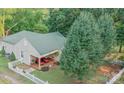 Eye-level view of a single-story home featuring a cozy front porch with red cushioned chairs and landscaped yard at 2407 Brookside Ave, Kannapolis, NC 28081