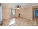 Bright living room with beautiful floors, neutral paint, large window, and modern ceiling fan at 2407 Brookside Ave, Kannapolis, NC 28081