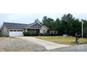 House exterior showcasing a gravel driveway and large yard at 249 Planters Row Rd, Iron Station, NC 28080