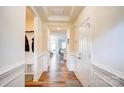 Bright entryway with hardwood floors, wainscoting, and built-in bench at 3936 Rothwood Ln, Harrisburg, NC 28075