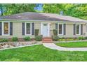 Charming home with updated landscaping, stone accents, and a well-manicured lawn leading to the front entrance at 4145 Wall St, Charlotte, NC 28209