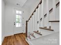 Inviting entryway featuring a wood floor, staircase, and a glass-paneled front door at 425 Delburg Mill Alley Dr, Davidson, NC 28036