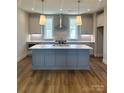 Modern kitchen featuring a large island, stainless steel appliances, and stylish pendant lighting at 429 Delburg Mill Alley Dr, Davidson, NC 28036