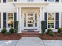 Modern front door with glass panels, flanked by columns and shrubs at 4342 Arborway None, Charlotte, NC 28211