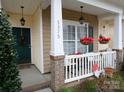 Inviting front porch with white railings and hanging flower baskets at 5375 Josephine Sw Ln, Concord, NC 28027