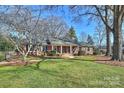 Ranch home with mature trees, landscaping, and a spacious lawn at 6511 Newhall Rd, Charlotte, NC 28270