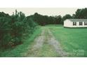 Gravel driveway leading to a mobile home in a wooded area at 74 Noble Cir, Wadesboro, NC 28170