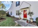 Red front door with sidelights and two potted trees at 8927 Bryant Field Cir, Charlotte, NC 28277