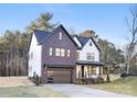 Modern farmhouse exterior with dark brick and white accents, attached garage, and inviting front porch at 10605 S Hampton Dr, Charlotte, NC 28227