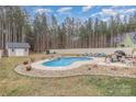 Backyard features a private pool with a waterfall, patio seating, and a fenced yard at 1076 Furnace Rd, Iron Station, NC 28080