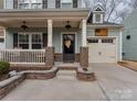 Inviting front entrance featuring a covered porch with brick columns and a decorated door at 3020 Graceland Cir # 11D, Pineville, NC 28134