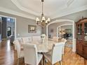 Elegant dining room with chandelier lighting, hardwood floors, and arched entryways at 3827 Bramwyck Dr, Charlotte, NC 28210