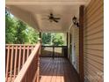 Covered front porch with wooden railings and ceiling fan at 5024 Victoria Ave, Charlotte, NC 28269