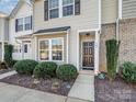 Townhouse exterior with landscaping, dark brown door, and neutral siding at 567 Fawnborough Ct, Rock Hill, SC 29732