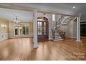 Grand foyer featuring hardwood floors, elegant staircase, large windows, and a striking front door at 7409 Stonecroft Park Dr, Charlotte, NC 28226