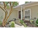 Inviting front porch with decorative plants, a stylish wreath, and outdoor seating at 1077 Sardis Cove Dr, Charlotte, NC 28270