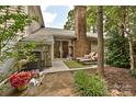 Private patio featuring lounge chairs, lush greenery, and an eye-catching brick fireplace at 1077 Sardis Cove Dr, Charlotte, NC 28270