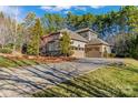Spacious home with a long driveway and a three-car garage, surrounded by lush trees at 11052 Preservation Park Dr, Charlotte, NC 28214