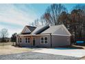 Side angle view of gray home with natural wood porch posts and a long driveway at 2222 Badin Rd, Albemarle, NC 28001