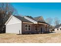 Angle view of a home's gray siding, black roof, and natural wood porch posts on a sunny day at 2222 Badin Rd, Albemarle, NC 28001