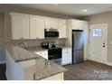 Modern kitchen with white cabinets, granite countertops, and stainless steel appliances at 2222 Badin Rd, Albemarle, NC 28001