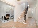 Elegant foyer featuring a staircase, light hardwood floors, and a view into the inviting living room at 2400 Mecklenburg Ave, Charlotte, NC 28205