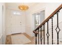 Bright foyer with hardwood floors, white walls, decorative chandelier, and staircase with iron railing at 2400 Mecklenburg Ave, Charlotte, NC 28205