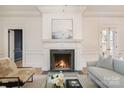 Cozy living room with a fireplace, marble surround, hardwood floors, and ample natural light at 2400 Mecklenburg Ave, Charlotte, NC 28205