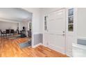 Inviting entryway featuring a white door, hardwood flooring, and an open view into the dining and living areas at 6000 Carmel Station Ave, Charlotte, NC 28226