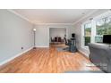 Bright living room with hardwood floors, large windows, and an open layout connecting to the dining area at 6000 Carmel Station Ave, Charlotte, NC 28226