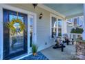 Front porch with black door, wreath, and two rocking chairs at 724 Mercer Pl, Huntersville, NC 28078