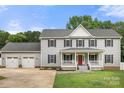 Charming two-story home features a welcoming front porch, three-car garage, and manicured lawn at 7545 Haley Ln, Indian Land, SC 29707