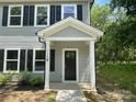 Close-up of the home's covered entrance, featuring a black front door with sidelight at 129 Sharon Rd, York, SC 29745