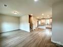 Open living room with light flooring and a view of the kitchen and staircase at 129 Sharon Rd, York, SC 29745