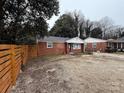 Brick ranch home with a spacious yard and a modern fence at 1401 Lasalle St, Charlotte, NC 28216