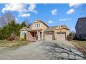 Two-story house with stone and shingle accents, two-car garage, and landscaped yard at 14818 Long Iron Dr, Huntersville, NC 28078