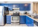 Stainless steel appliances and blue cabinetry in updated kitchen at 182 Water Oak Dr, Pineville, NC 28134